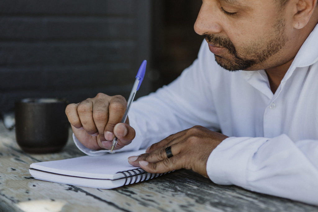 Writer noting down the pros and cons of traditional publishing